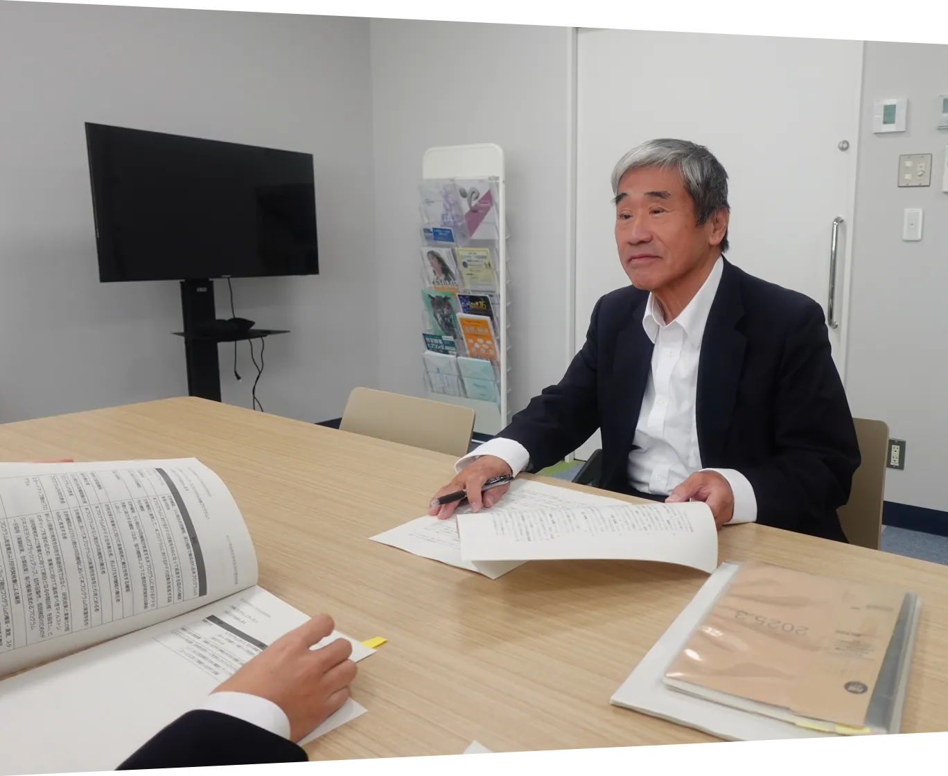 支援担当者と関係者が会議室で書類を確認しながら打ち合わせを行っている様子