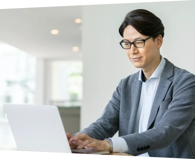 ノートパソコンで作業を行うビジネスパーソンの様子